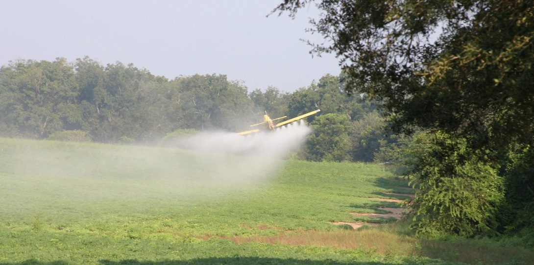 Plane spraying water on top of a field