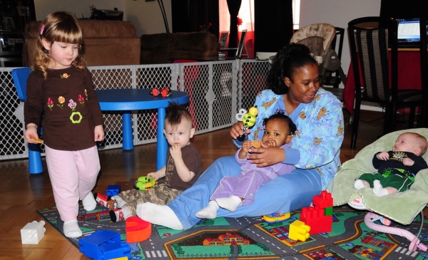 A woman plays with children at a home child care location.