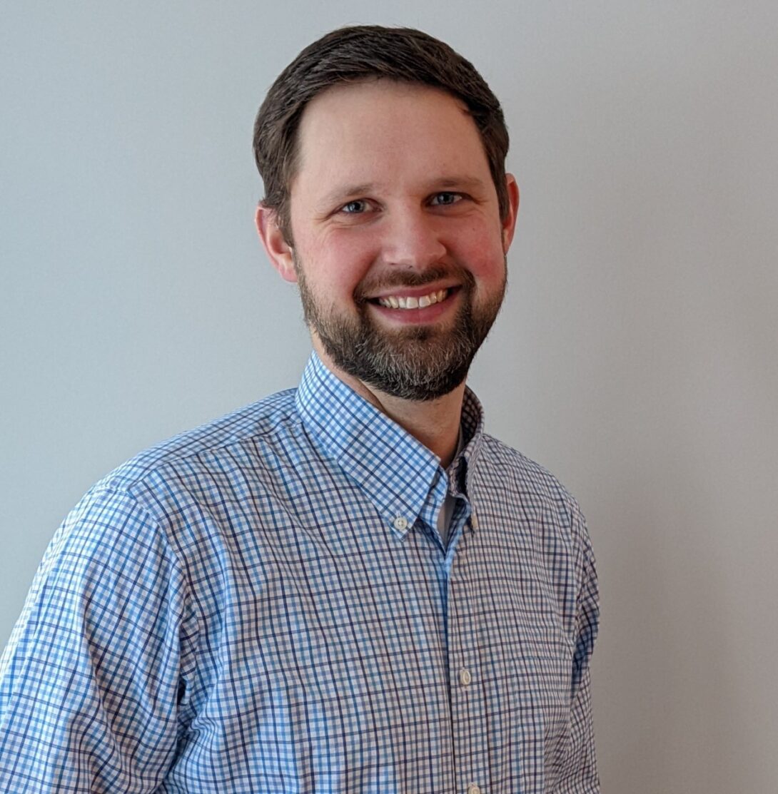 Dr. Zagorski wearing a plaid shirt smiling for a photo.